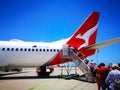 People boarding a Qantas domestic airline Aircraft Type: Boeing 737 on the runway.